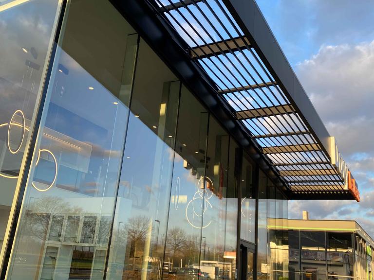 Renson Icarus structurele zonwering geplaatst door Demaeght zonwering aan de showroom van Dovy Keukens te Sint-martens-latem. Een modern en strak design met Belgische architectuur en kwaliteit met outdoor design.