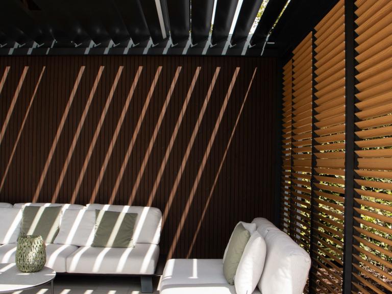 Renson Camargue terrasoverkapping geplaatst door Demaeght zonwering te Dilbeek. Een aluminium pergola gecombineerd met een houten tuinberging met zwart gelakte houten profielen. Combo tussen berging en outdoor living. Design architectuur tuin terras inspiratie offerte West-vlaanderen Oost-vlaanderen Deinze Kortrijk Tielt Roeselare Brugge Oudenaarde Kluisbergen Ronse Dilbeek Brussel Leuven