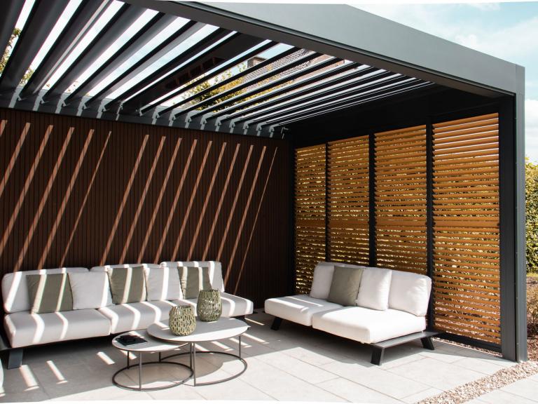 Renson Camargue terrasoverkapping geplaatst door Demaeght zonwering te Dilbeek. Een aluminium pergola gecombineerd met een houten tuinberging met zwart gelakte houten profielen. Combo tussen berging en outdoor living. Design architectuur tuin terras inspiratie offerte West-vlaanderen Oost-vlaanderen Deinze Kortrijk Tielt Roeselare Brugge Oudenaarde Kluisbergen Ronse Dilbeek Brussel Leuven