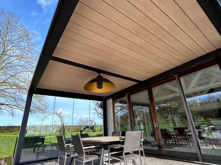 Renson Camargue lamellendak geplaatst door Demaeght zonwering te Doornik. Een aluminium pergola gemonteerd aan de woning. Schuifglas en geïntegreerde zonwering. Ook led-verlichting alsook een Lineo Fix lamel met een Heatsail verwarming eraan. Deinze Waregem Kortrijk Ronse Kluisbergen. Vraag hier uw vrijblijvende offerte op maat.